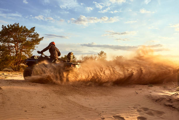 Racing powerful quad bike on the difficult sand in the summer.