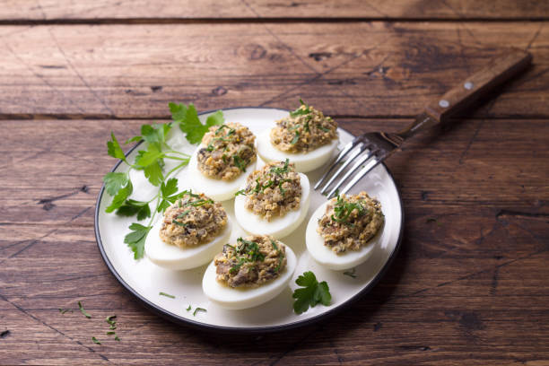 istock Stuffed eggs with mushrooms, cream cheese and parsley on a wooden table 1140438568