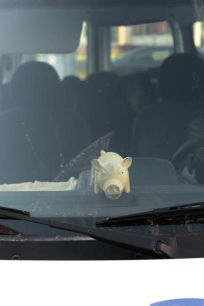 istock Cute fat pig toy behind a car's windshield window 1140440511