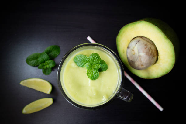 istock Avocado smoothie with lime and mint on black background. Top view with selective focus. 1140445481