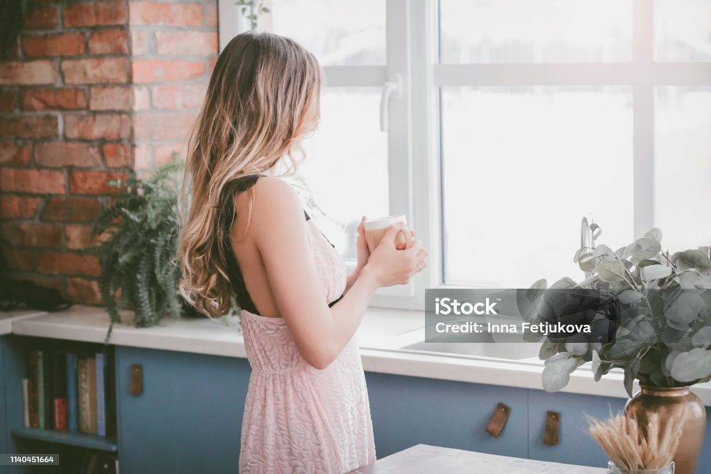 And time has stopped. Woman drinking coffee in the morning breakfast on the kitchen bedroom relax at home healthy lifestyle concept. Sunrise from window Morning Stock Photo