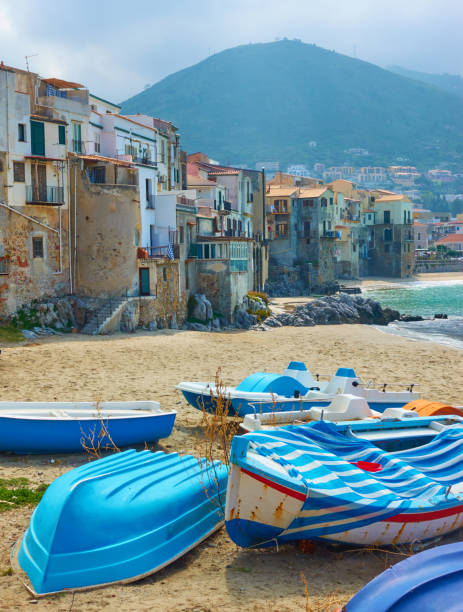 Boats on the sandy beach in the old town of Cefalu in Sicily, Italy