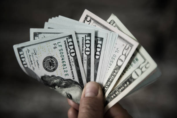 istock Unrecognizable mature person holding US Dollar bills 1140452693