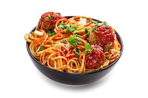 Delicious spaghetti pasta with meatballs and tomato sauce in a bowl. Traditional American Italian food isolated on white background.