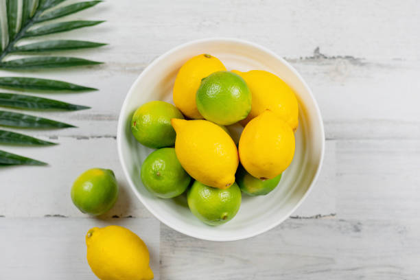 istock Fresh lemons and limes on white wooden background 1140453991