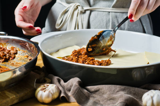 der küchenchef kocht hausgemachte italienische lasagne. seitenansicht, platz für text. - tomato sauce domestic kitchen meat cheese stock-fotos und bilder