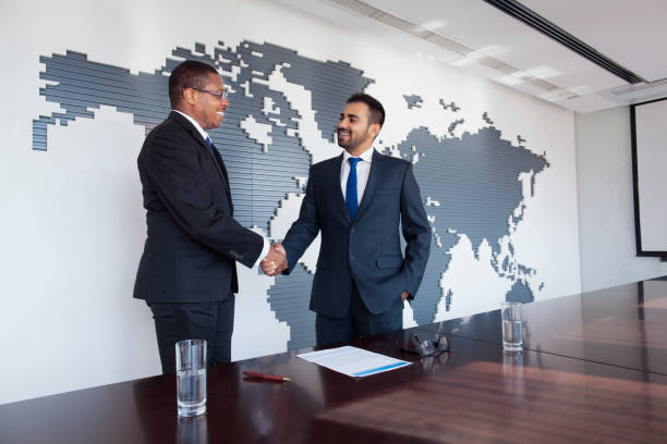会議のテーブルで握手するビジネスマン - board room discussion contract agreement ストックフォトと画像