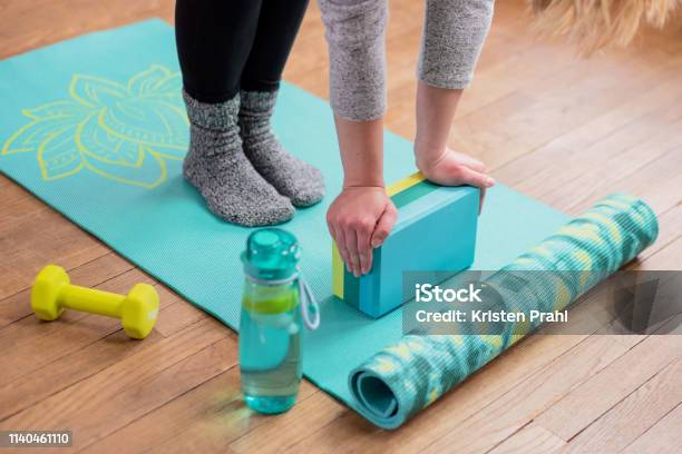 Girl With Hands On Yoga Block Stretching Stock Photo - Download Image Now - Yoga Block, Dumbbell, Exercise Mat