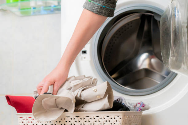 istock woman put dirty clothes into the washing machine 1140465180