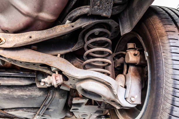 Used vehicle shock absorber and control arm in a repair shop stock photo