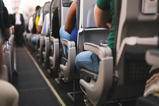 Interior de avión con pasajeros en asientos photo
