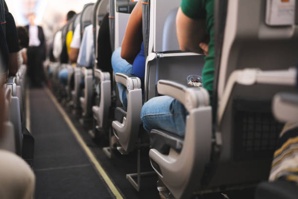interior of airplane with passengers on seats - vehicle seat imagens e fotografias de stock