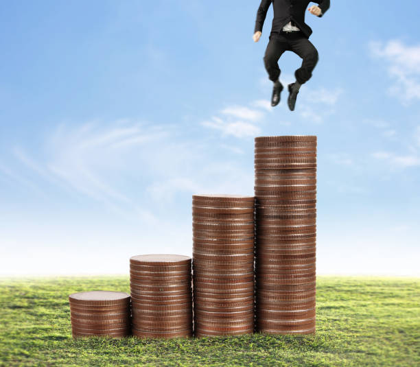 istock Businessman walk on stack of coins which grows success 1140480377