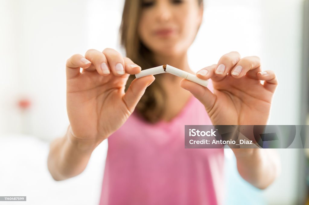 Leaving Bad Habit Closeup of woman's hands breaking cigarette to fight addiction Smoking Issues Stock Photo