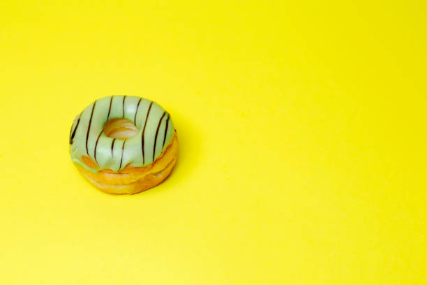 istock green chocolate donut on yellow background and space for your advertising. 1140492001