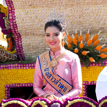 Chiang Mai, Thailand-February 4th 2017 : Miss flower festival : a very pretty woman in traditional clothes carrying the crown of the beauty queen. She wears the queen scarf, the crown, luxurious jewellery: necklace, earrings,and a pin.