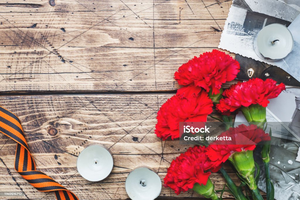 Cartolina 9 maggio - garofani rossi Nastro George Vecchie foto su uno sfondo di legno. Simbolo di vittoria nella grande guerra patriottica - Foto stock royalty-free di A forma di stella