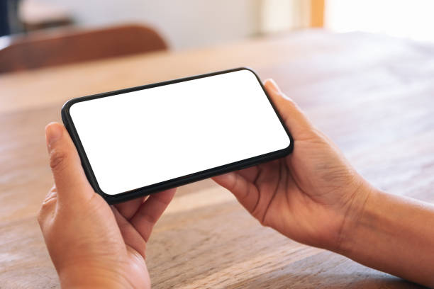 istock woman's hands holding black mobile phone with blank white screen 1140515916