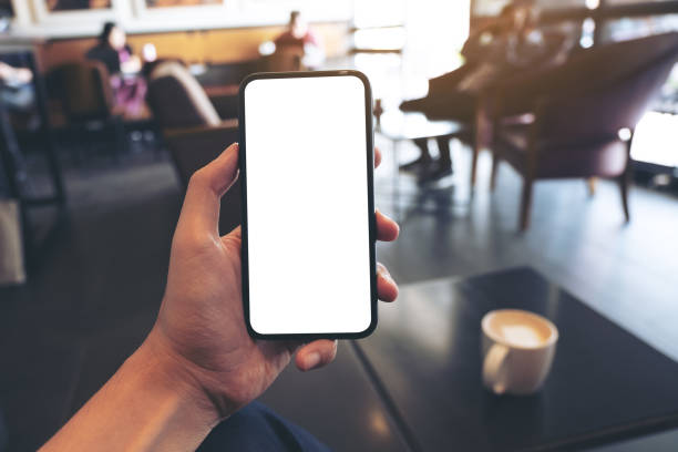 istock a hand holding and showing black mobile phone with blank white screen 1140516000