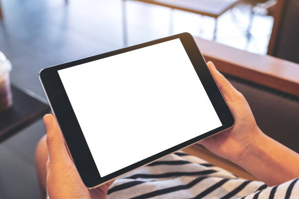 istock a woman sitting and holding black tablet pc with blank white desktop screen 1140516003