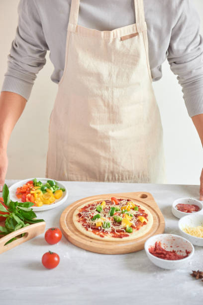 raw pizza with ingredients in the background - pizza sauces chef making imagens e fotografias de stock