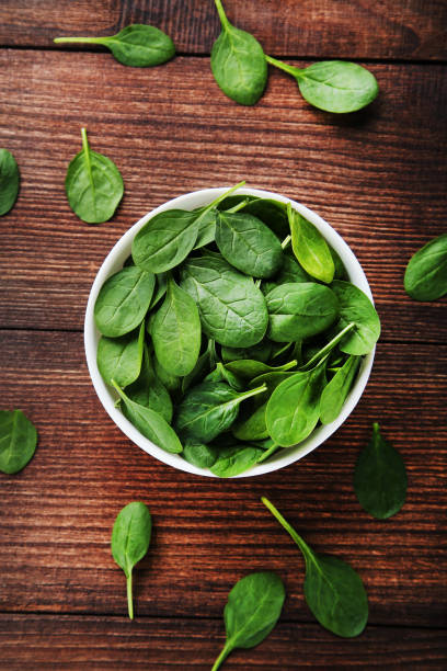 istock Spinach leafs in bowl on brown wooden table 1140520038
