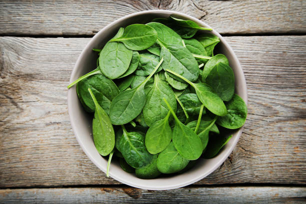 istock Spinach leafs in bowl on gray wooden table 1140520078
