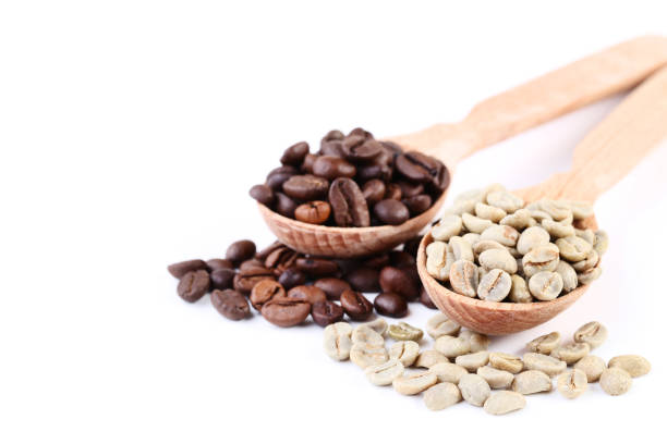 istock Green and brown coffee beans in spoons isolated on white background 1140520684