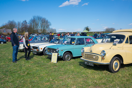 Thriplow, Cambridge, England, UK - March 2019: Classic old car vintage show exhibition held in an open field outdoor with people watching the vehicles.