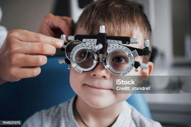 Tuning The Intrument Little Boy With Phoropter Having Testing His Eyes In The Doctors Office Stock Photo - Download Image Now