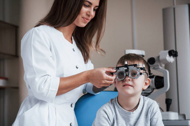 istock Oftalmolog corrects device. Child sitting in the doctor's cabinet and have tested his visual acuity 1140521107