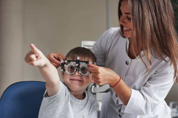 istock Smiling and reading. Child sitting in the doctor's cabinet and have tested his visual acuity 1140521687