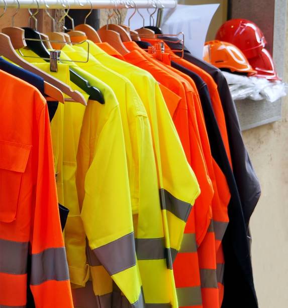 istock High visibility jackets on a hanger with protective helmets behind, in a work clothes store 1140524541