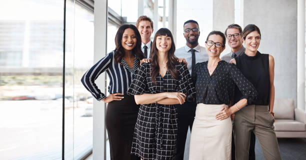 We're the award winning team! Shot of a group of well-dressed businesspeople standing together organised group photo stock pictures, royalty-free photos & images