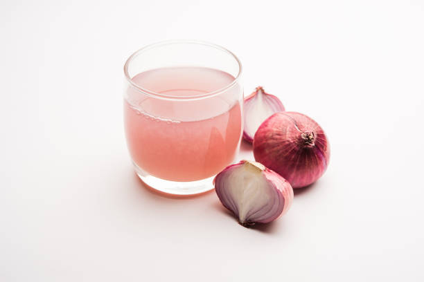 Medicinal Onion juice/syrup in a glass with raw onions. selective focus stock photo