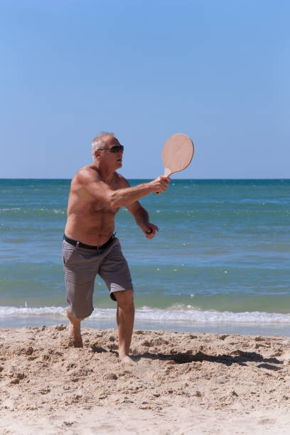istock handsome grown man playing tennis on the beach 1140525341