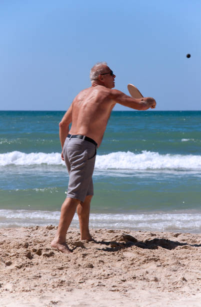 istock handsome grown man playing tennis on the beach 1140525389