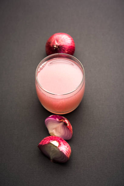 Medicinal Onion juice/syrup in a glass with raw onions. selective focus stock photo