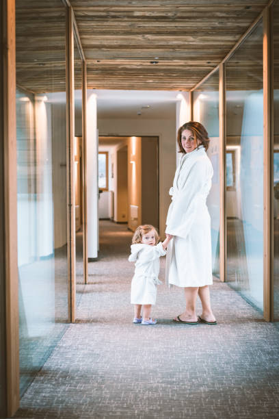 istock Mother and daughter holding hands wearing a bathrobe 1140526594