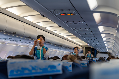 SUVANNABHUMI AIRPORT, BANGKOK, THAILAND - MARCH 23, 2019 : Flight attendants demonstrate the proper use of oxygen masks before flight