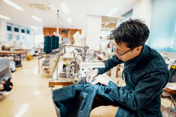 istock Mid adult man making denim jeans on a sewing machine at a textile studio 1140527346