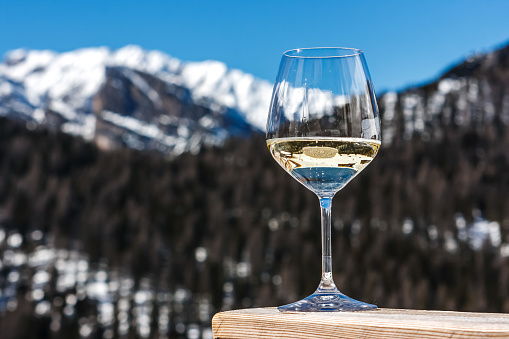 Picture of a glass of white sparkling Prosecco wine in a lodge in Cortina d'Ampezzo, Dolomites, Italy