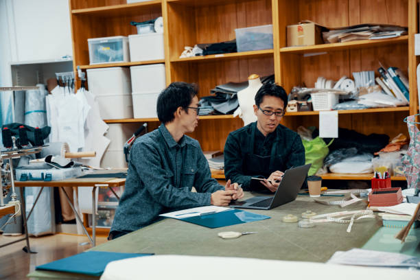 istock Mid adult design professionals working at a computer in a textile factory 1140528842