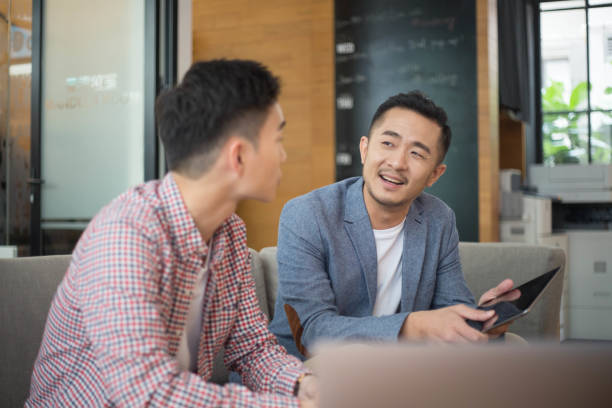 istock Young Asian Businessmen Talking in Co-Working Space 1140531098