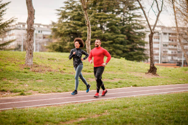 istock Active young couple running next to each other in a city park 1140533209