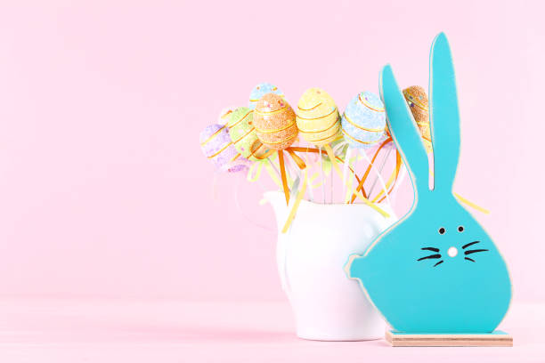 istock Wooden rabbit with easter eggs on pink background 1140533334
