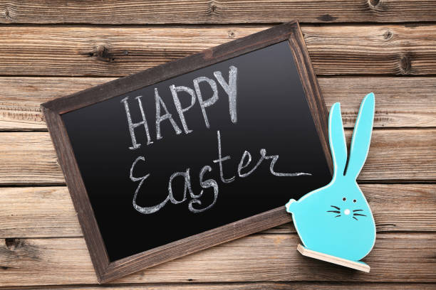 istock Blue rabbit and frame with text Happy Easter on brown wooden table 1140533923