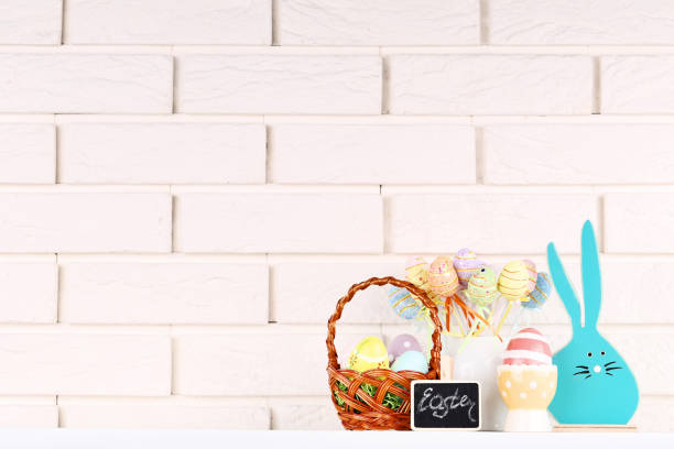 istock Wooden rabbit with colorful easter eggs on brick wall background 1140534321