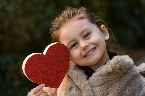 Little girl holding heart shape
