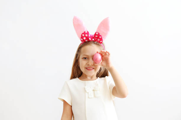 istock Smiling girl with bunny ears, white wall copy space background. 1140539372